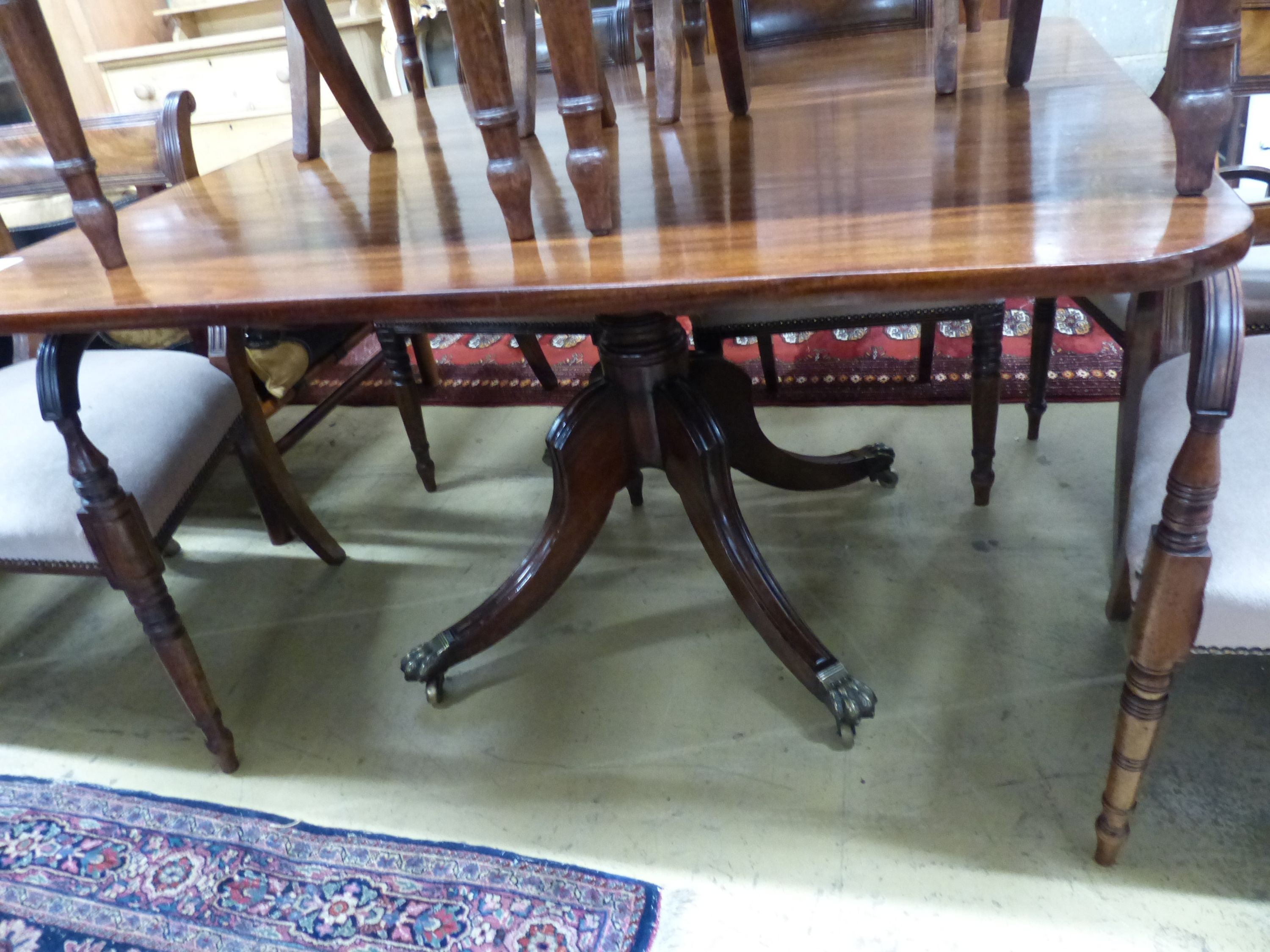 A Regency mahogany tilt top dining table, together with a harlequin set of ten Regency mahogany dining chairs (four with arms), table 122 x 118cm H.72cm